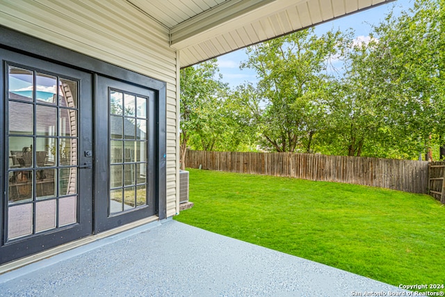 view of yard with french doors, cooling unit, and a patio area