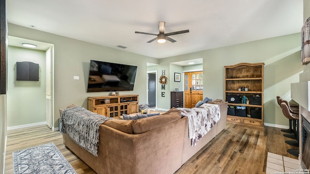 living room with wood-type flooring and ceiling fan