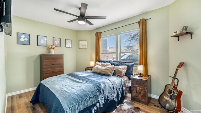 bedroom with dark hardwood / wood-style flooring and ceiling fan