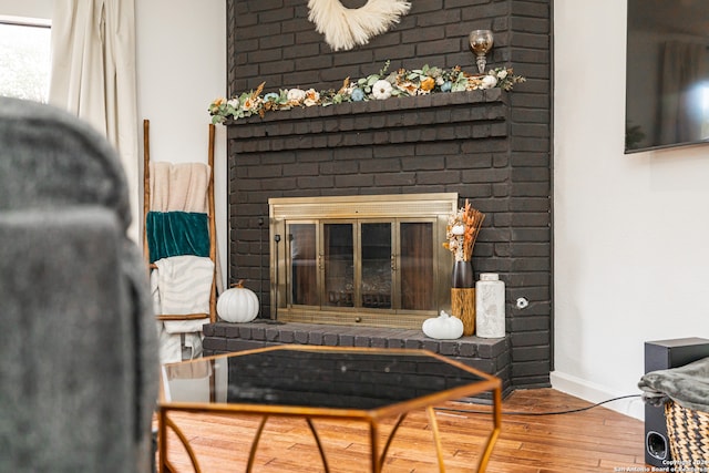 room details with wood-type flooring and a brick fireplace