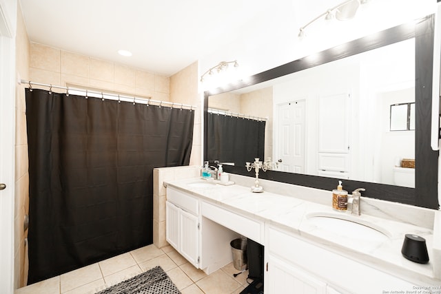 bathroom featuring toilet, vanity, tile patterned floors, and curtained shower