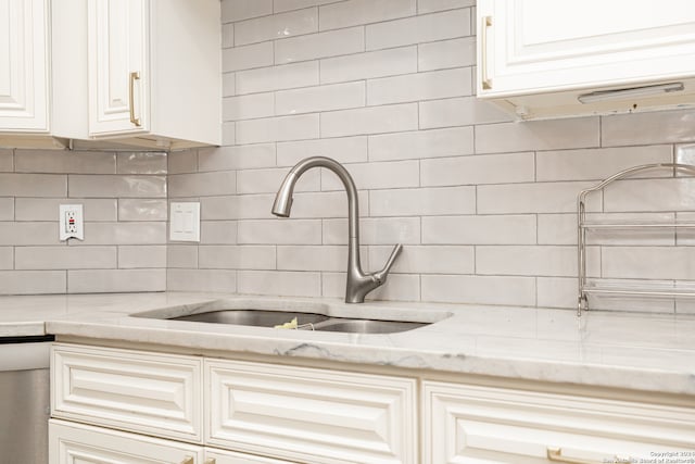 kitchen featuring light stone countertops, sink, and tasteful backsplash