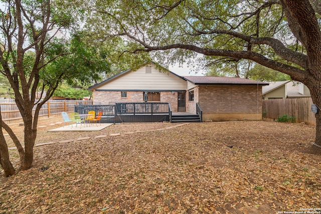 rear view of house featuring a patio and a wooden deck