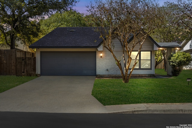 view of front facade with a garage and a lawn