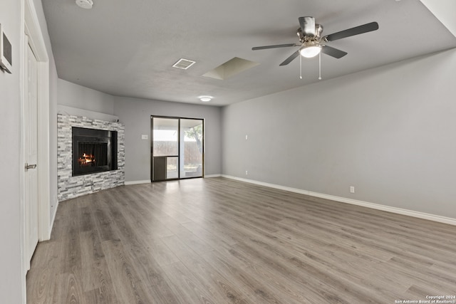 unfurnished living room featuring ceiling fan, wood-type flooring, and a fireplace