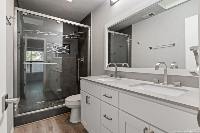 bathroom featuring vanity, an enclosed shower, toilet, and wood-type flooring