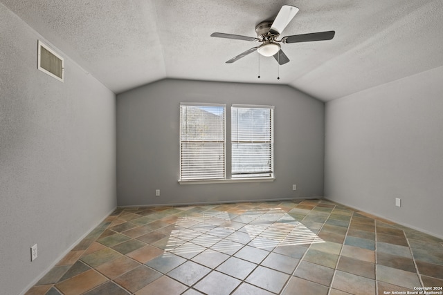 additional living space featuring lofted ceiling, a textured ceiling, and ceiling fan