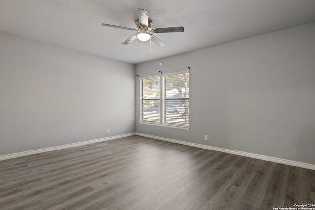 unfurnished room featuring dark hardwood / wood-style floors and ceiling fan