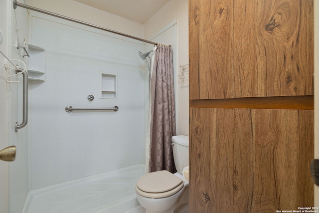 bathroom featuring a shower with shower curtain, a textured ceiling, and toilet