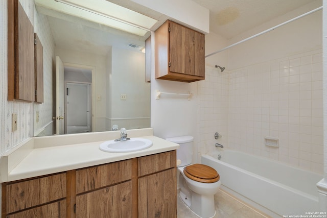 full bathroom with toilet, tile patterned flooring, tiled shower / bath, vanity, and a textured ceiling