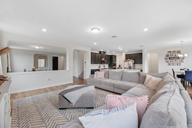 living room with a chandelier and light hardwood / wood-style flooring