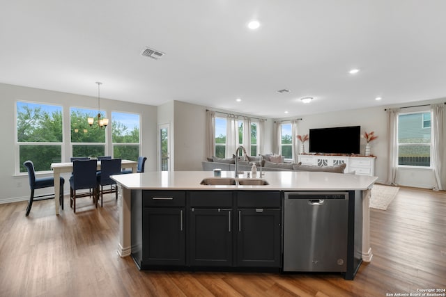 kitchen with sink, pendant lighting, dishwasher, and an island with sink