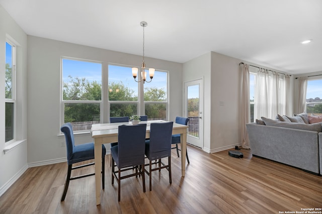 dining room featuring a wealth of natural light, an inviting chandelier, and light hardwood / wood-style floors