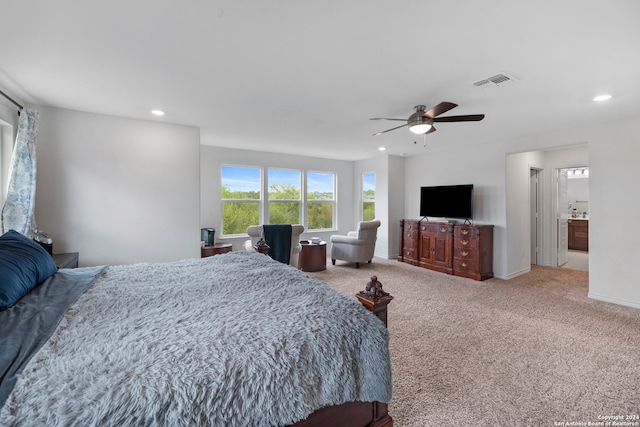 bedroom featuring light colored carpet, connected bathroom, and ceiling fan