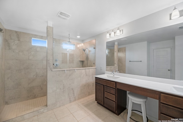 bathroom featuring a tile shower, tile patterned floors, and vanity