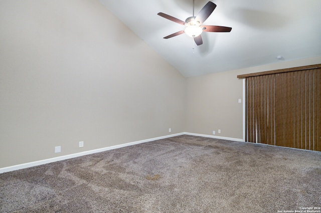 empty room with vaulted ceiling, carpet flooring, and ceiling fan