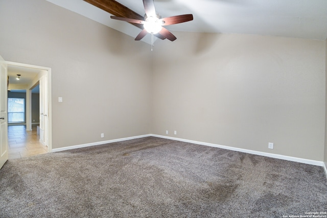 spare room featuring ceiling fan, light colored carpet, and vaulted ceiling