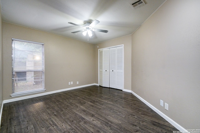 unfurnished bedroom with a closet, ceiling fan, and dark hardwood / wood-style floors