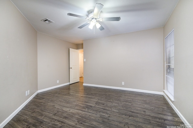 spare room with dark wood-type flooring and ceiling fan