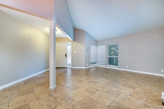 unfurnished room featuring high vaulted ceiling