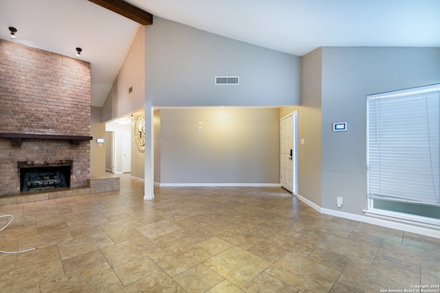 unfurnished living room featuring beam ceiling, a brick fireplace, and high vaulted ceiling