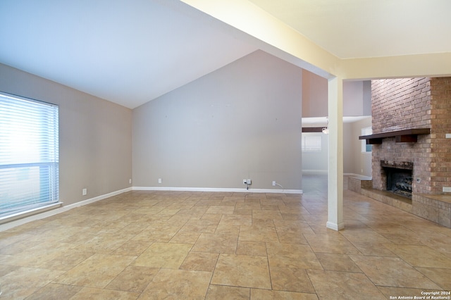 unfurnished living room with high vaulted ceiling and a fireplace