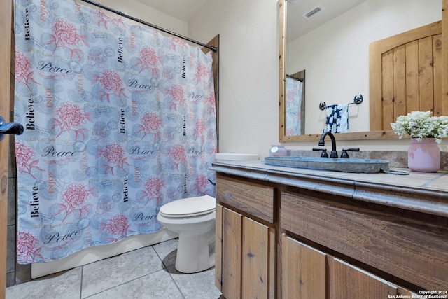 bathroom with vanity, curtained shower, toilet, and tile patterned flooring