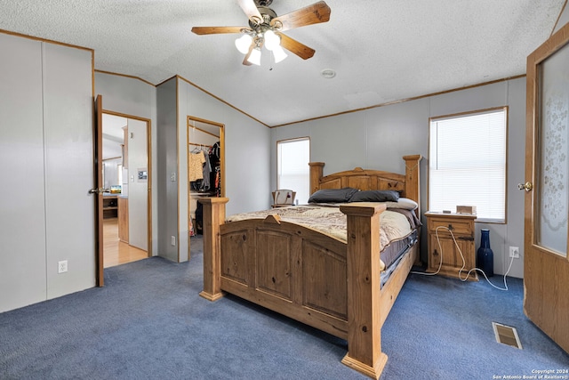 carpeted bedroom with lofted ceiling, multiple windows, a textured ceiling, and ceiling fan