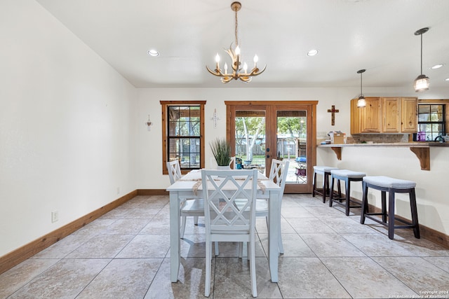 dining space featuring french doors, a notable chandelier, and light tile patterned floors