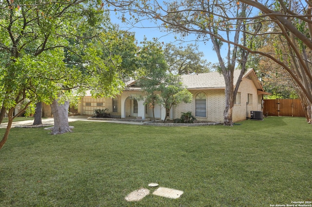 view of front of home featuring cooling unit and a front lawn