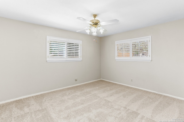 carpeted spare room featuring ceiling fan