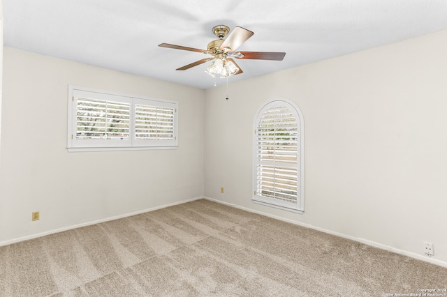 carpeted empty room with ceiling fan and a healthy amount of sunlight