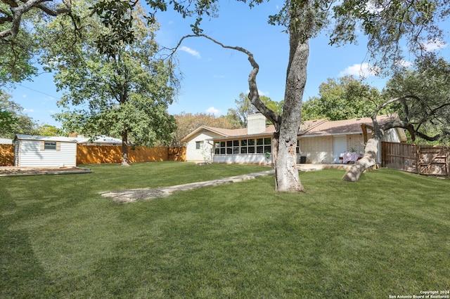 view of yard with a sunroom and an outbuilding