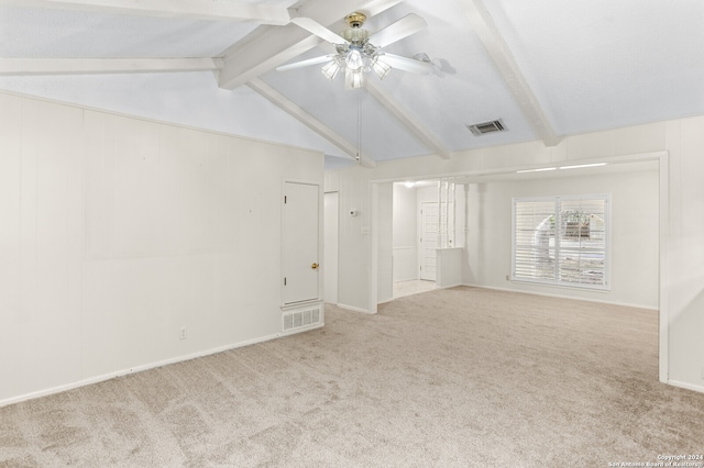 carpeted empty room with ceiling fan and vaulted ceiling with beams