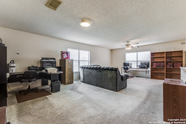 living room with a textured ceiling, carpet flooring, plenty of natural light, and ceiling fan