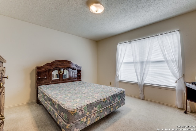 carpeted bedroom featuring a textured ceiling