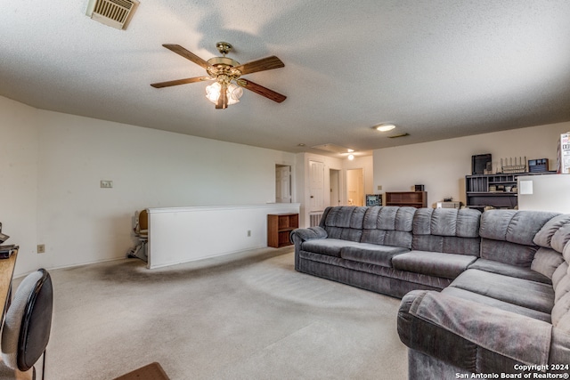 carpeted living room featuring a textured ceiling and ceiling fan