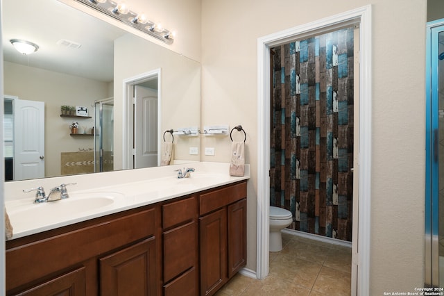 bathroom with toilet, a shower with curtain, vanity, and tile patterned floors