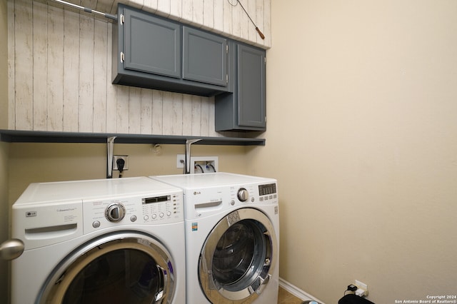 washroom with cabinets and washer and clothes dryer