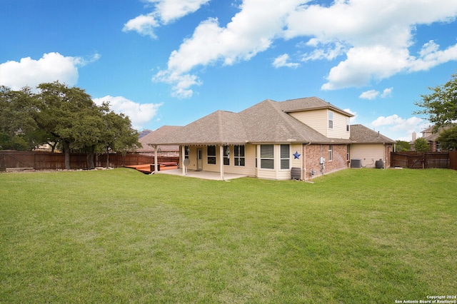 rear view of house with a patio area, central AC unit, and a lawn