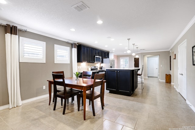 tiled dining room with ornamental molding and a textured ceiling