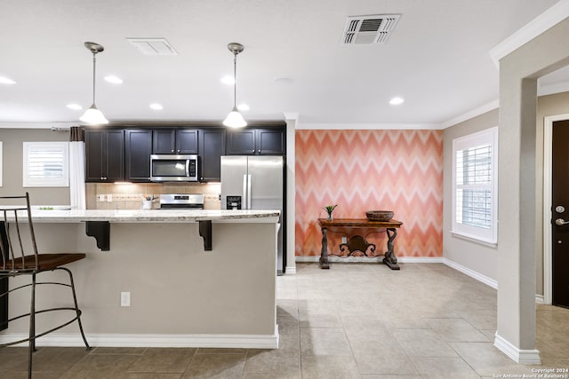 kitchen featuring appliances with stainless steel finishes, a center island, plenty of natural light, and pendant lighting