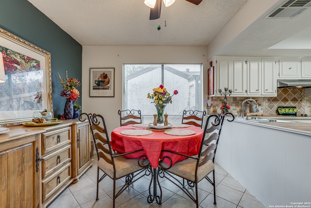 dining space with sink, ceiling fan, a textured ceiling, and light tile patterned floors