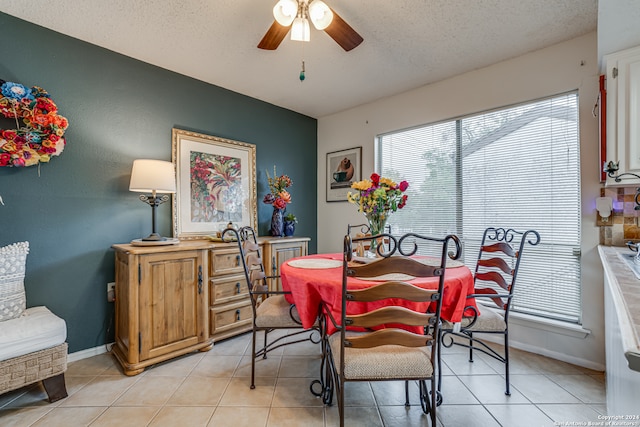 dining room featuring a textured ceiling, light tile patterned floors, and ceiling fan