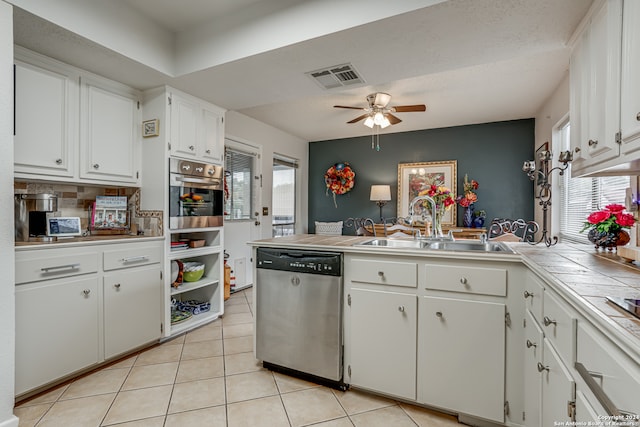 kitchen featuring ceiling fan, stainless steel appliances, tile counters, white cabinets, and light tile patterned floors