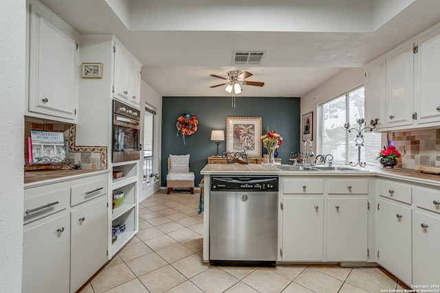 kitchen featuring backsplash, sink, white cabinets, light tile patterned flooring, and appliances with stainless steel finishes