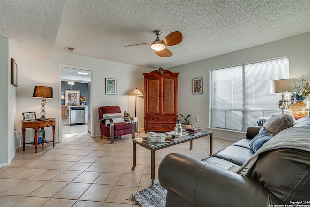 tiled living room with ceiling fan and a textured ceiling