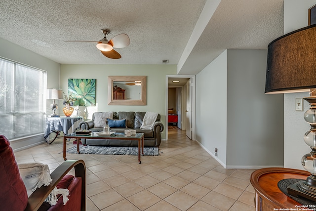 living room featuring ceiling fan, a textured ceiling, and light tile patterned flooring