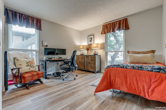 bedroom with hardwood / wood-style floors and a textured ceiling