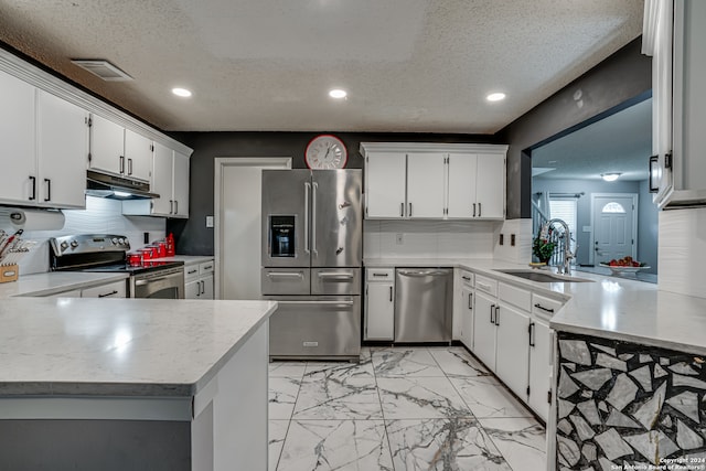 kitchen with sink, appliances with stainless steel finishes, kitchen peninsula, and white cabinets